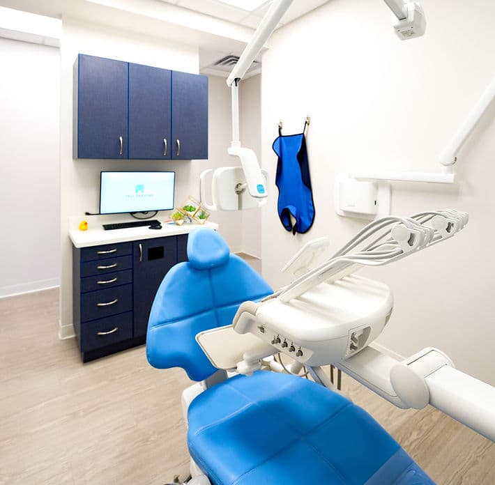 Treatment room at Troy Meadows Dental with a blue dental chair and navy cabinetry